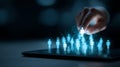 A human hand elevating a sparkling, brightly glowing individual icon above a digital crowd on a tablet screen, symbolizing talent Royalty Free Stock Photo