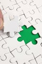 The human hand fills the last missing elements of the surface from the jigsaw puzzle. The concept of the completion of the initiat Royalty Free Stock Photo
