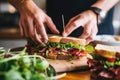 human hand garnishing a sandwich and a salad on the side