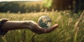 Human Hand Gently Holding Miniature Green Earth-like Planet, Trees and Grass, Serene Meadow Background Royalty Free Stock Photo
