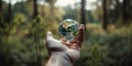 Human Hand Gently Holding Miniature Green Earth-like Planet, Trees and Grass, Serene Meadow Background Royalty Free Stock Photo