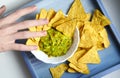 Human hand grab nachos corn chips with guacamole sauce close up photo Royalty Free Stock Photo