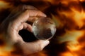 Human hand hold globe,fire flame screen. Royalty Free Stock Photo