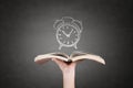 Human hand holding book with clock. Royalty Free Stock Photo
