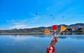 Human hand holding colorful lollipops against the artificial lake