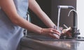 Human hand holding glass pouring fresh drink water at kitchen faucet Royalty Free Stock Photo