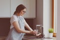 Human hand holding glass pouring fresh drink water at kitchen faucet Royalty Free Stock Photo