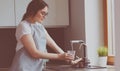 Human hand holding glass pouring fresh drink water at kitchen faucet Royalty Free Stock Photo