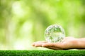 Human hand holding globe planet glass In green forest with bokeh nature lights. world environment day. concept for environment Royalty Free Stock Photo