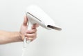 The human hand is holding a hairdryer. Royalty Free Stock Photo