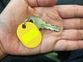 Human hand holding a key with empty yellow tag sign space Royalty Free Stock Photo