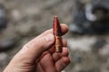 Human hand holding a large-caliber 12.7mm armor-piercing incendiary bullet