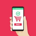 Human hand holding mobile phone with shopping cart and pay button on the screen. Royalty Free Stock Photo