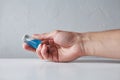 Human hand holding an old glass vial filled with cyan blue liqui