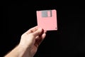 Human hand holding pink floppy disk Royalty Free Stock Photo