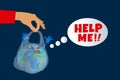 Human hand holding plastic bag with earth planet character saying help me Royalty Free Stock Photo