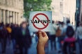 Human hand holding a protest banner stop vaping message over a crowded street background. Banning flavored vaping products to