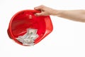 Human hand holding a red hard hat with money Royalty Free Stock Photo