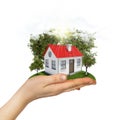 Human hand holding small house with trees and Royalty Free Stock Photo