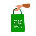 Human hand holding textile bag with Zero waste inscription. Green textile reusable shopping bag. Environmentally