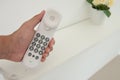 Human hand is holding the white office telephone Royalty Free Stock Photo