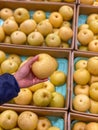 Human hand holding a yellow fresh pear at fruit store Royalty Free Stock Photo