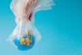 The human hand holds the planet earth in a plastic bag. The concept of pollution by plastic debris. Global warming due to Royalty Free Stock Photo