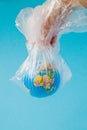 The human hand holds the planet earth in a plastic bag. The concept of pollution by plastic debris. Global warming due to Royalty Free Stock Photo