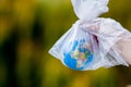 The human hand holds the planet earth in a plastic bag. The concept of pollution by plastic debris. Global warming due to Royalty Free Stock Photo