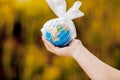 The human hand holds the planet earth in a plastic bag. The concept of pollution by plastic debris. Global warming due to Royalty Free Stock Photo