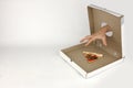 Human hand through hole in fastfood box try to takes last piece of pizza, white background, concept of greed