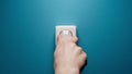 Human hand inserts a plug into an electrical outlet on a blue wall Royalty Free Stock Photo