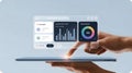 Human Hand Interacting with a Modern Translucent UI Dashboard Above a Tablet, Showcasing Business Analytics, Checklists, and Task Royalty Free Stock Photo