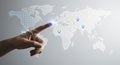 A human hand interacts with a digital world map, prominently displaying