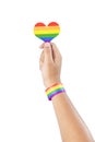 Human hand with LGBT rainbow flag wristband holding rainbow heart
