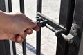 Human hand locking the bolt. Steel sliding bolt lock on the gate.