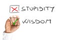 Human Hand Marking X on Stupidity and Check on Wisdom