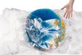 Human hand near the globe which is all in plastic, our irresponsible, excessive consumption of plastic