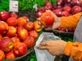 Human hand picking an apple and using bio-plastic bag