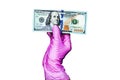 Human hand in pink rubber medical glove holds one hundred us dollar banknote on white background isolated closeup viral protection Royalty Free Stock Photo