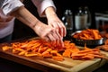 human hand preparing raw sweet potato fries Royalty Free Stock Photo