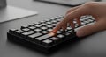 Human hand pressing enter key on black mechanical computer keyboard with glowing orange light highlighting action and execution in Royalty Free Stock Photo