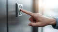 Human hand pressing a metal elevator call button, offering accessibility and convenience in a contemporary building Royalty Free Stock Photo