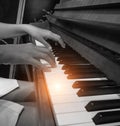 The human hand is pressing on piano key,playing music,black and white tone