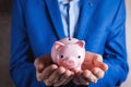 Human hand protecting a piggy bank Royalty Free Stock Photo