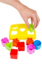 Human hand puts wrong shape into shape sorter toy isolated Royalty Free Stock Photo