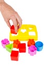 Human hand puts wrong shape into shape sorter toy isolated