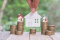 Human hand putting house  on coins stack. Concept for property ladder, mortgage and real estate investment Royalty Free Stock Photo