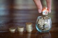 Human hand putting house model on coins stack. Concept for property ladder, mortgage and real estate investment Royalty Free Stock Photo