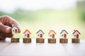 Human hand putting house model on coins stack. Concept for property ladder, mortgage and real estate investment Royalty Free Stock Photo